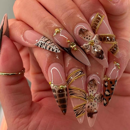 Model wearing mocha leopard butterfly 3D stiletto press-on nails with gold accents